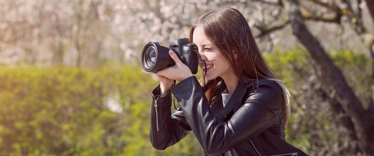 Beautiful female photographer working outdoors