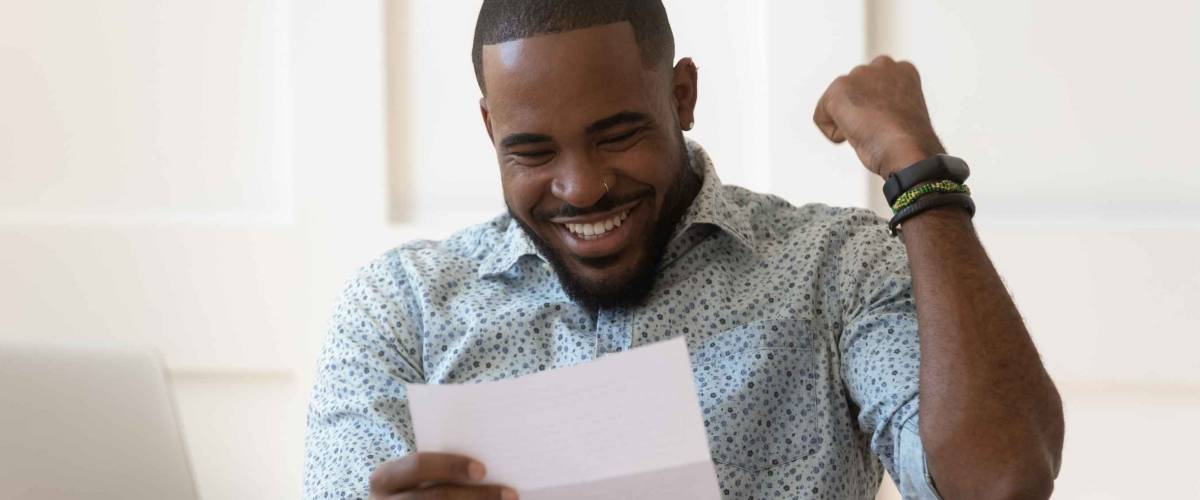 Happy euphoric young african american guy received paper