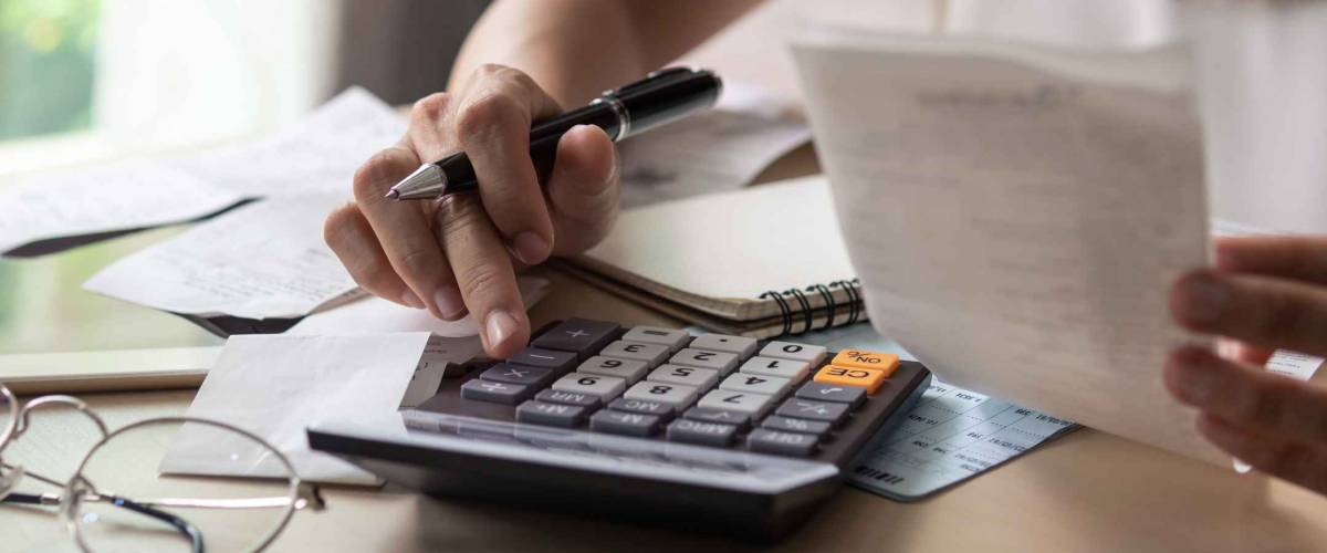 woman with papers and calculators adding up sums