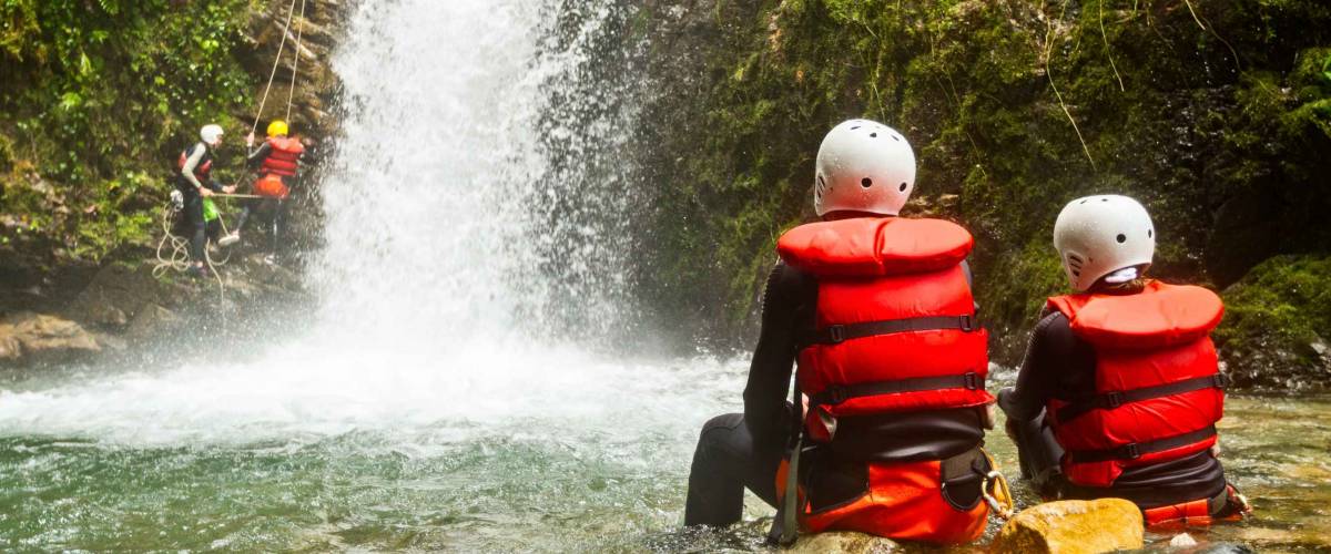 Couple in life vests enjoying a waterfall in Ecuador