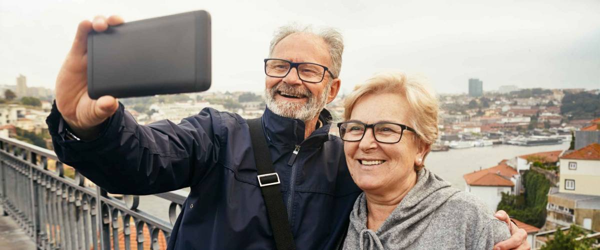 Happy moments. Cheerful senior couple in casual clothes making a selfie while enjoying a trip to Portugal