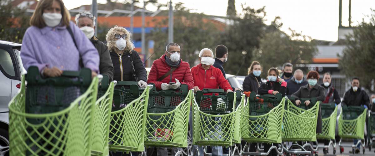 lineup of shoppers at supermarket with grocery carts