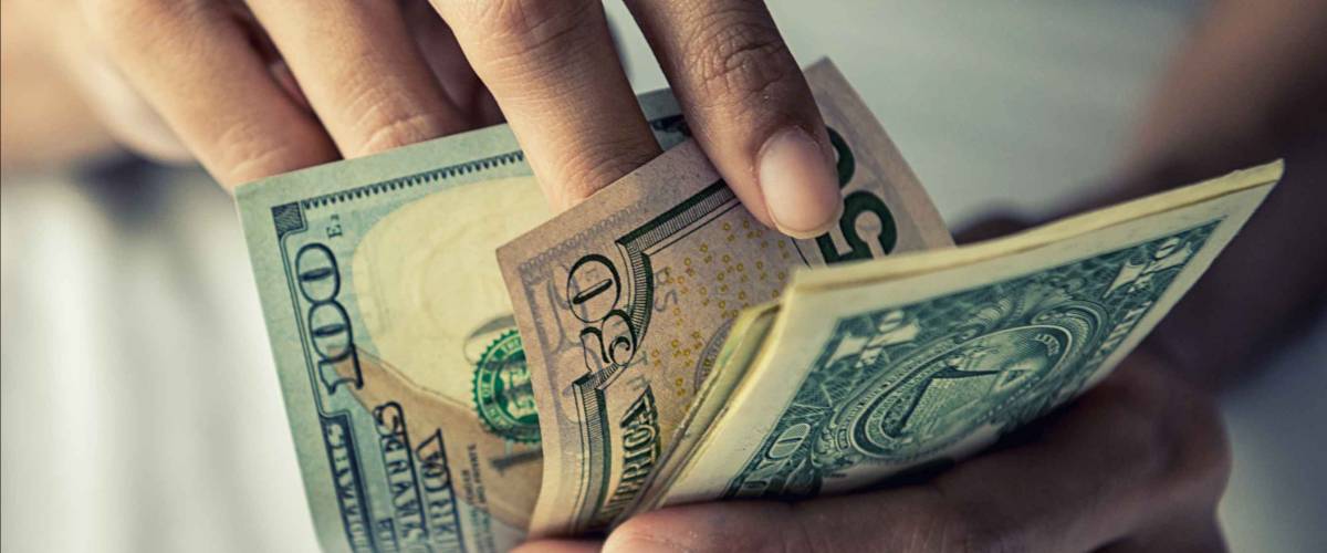 close up of hands holding and counting American bills