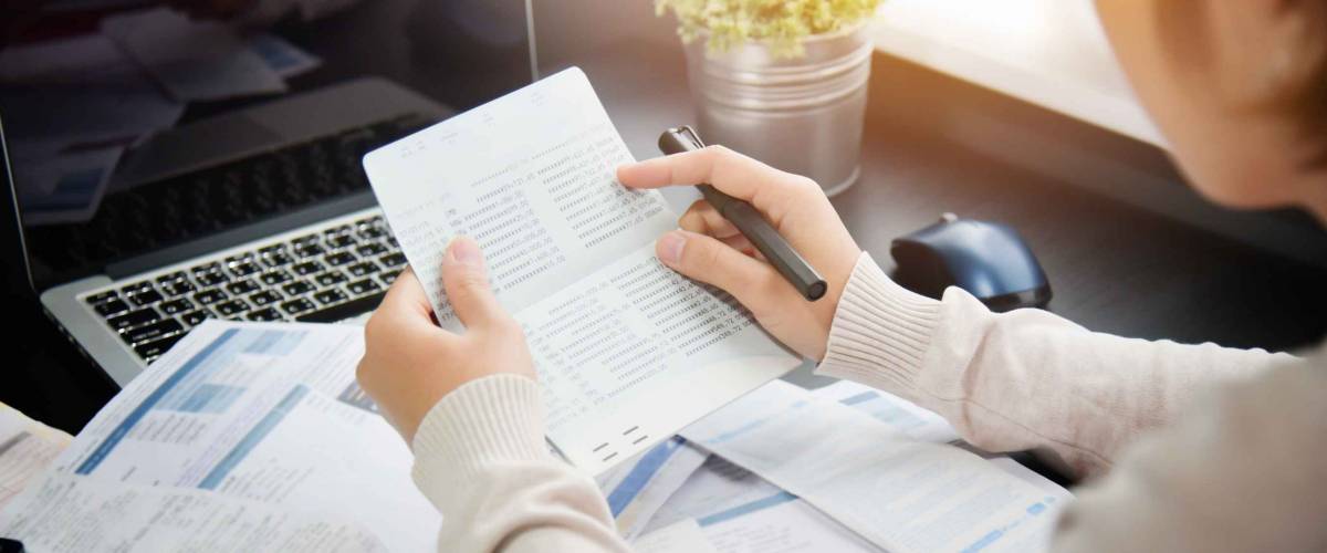 woman holding up papers with many more spread below