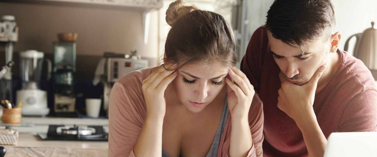 stressed couple looking confused and down