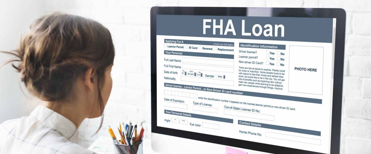 woman looks at computer screen with FHA loan open on it