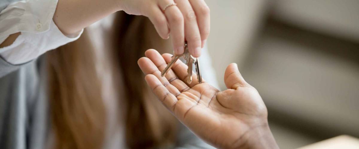 woman hands over keys to open hand