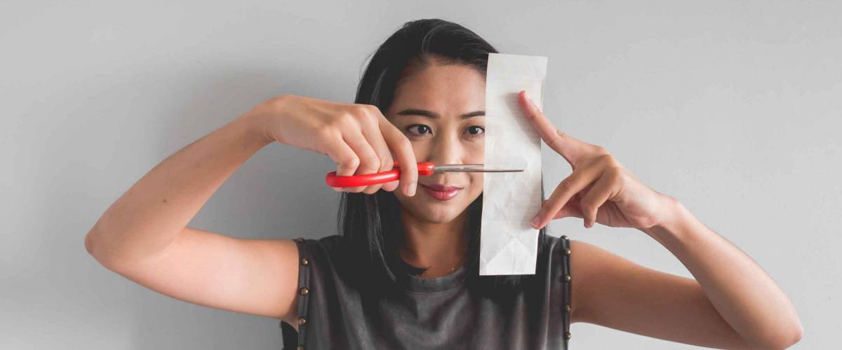 Asian woman plan to cut a bill into pieces.
