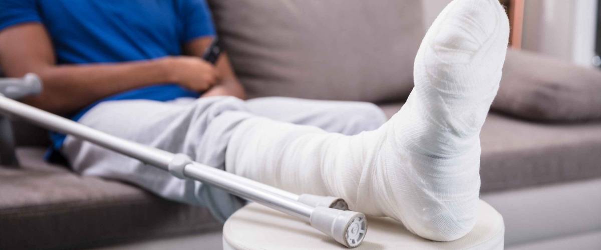 Close-up Of A Man's Broken Leg And Crutches