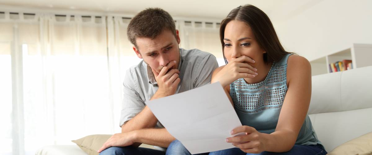 Worried couple reviewing loan agreement