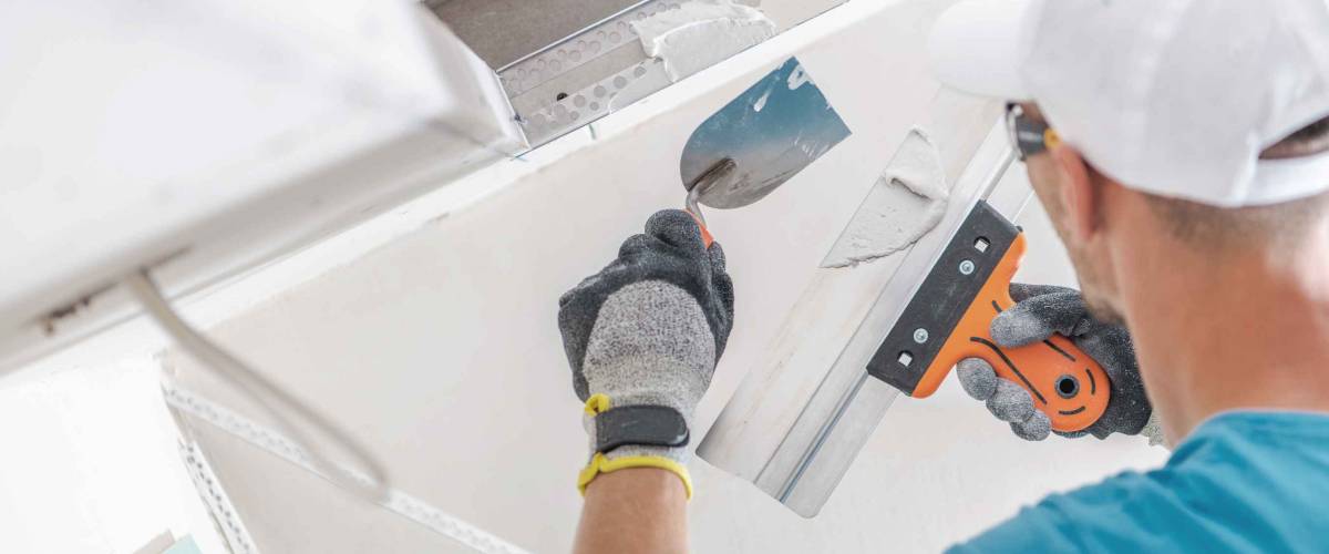 man filling in holes in drywall
