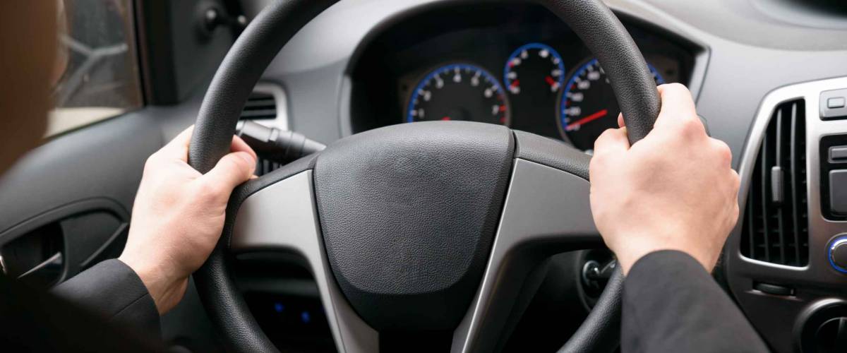 Close-up Of A Man Hands Holding Steering Wheel While Driving Car