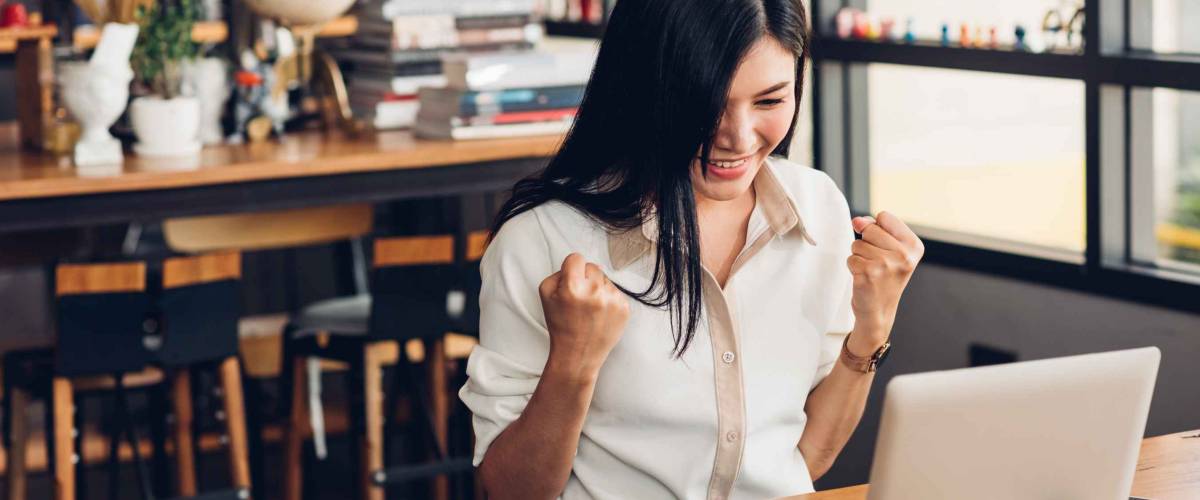 Lifestyle freelance business woman working with laptop computer he has glad on the job in coffee shop