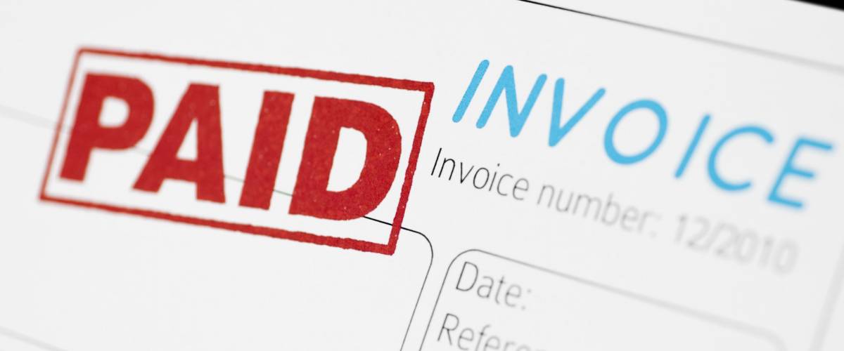 Close-up picture of an invoice with red paid stamp.