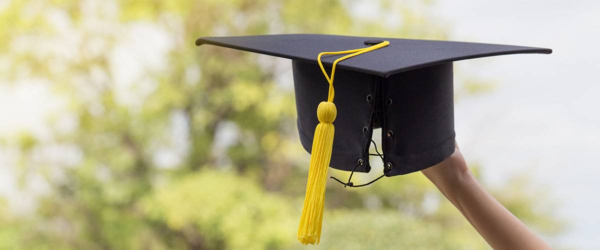 Graduate celebrating with cap in her hand,feeling so proud and happiness in Commencement day