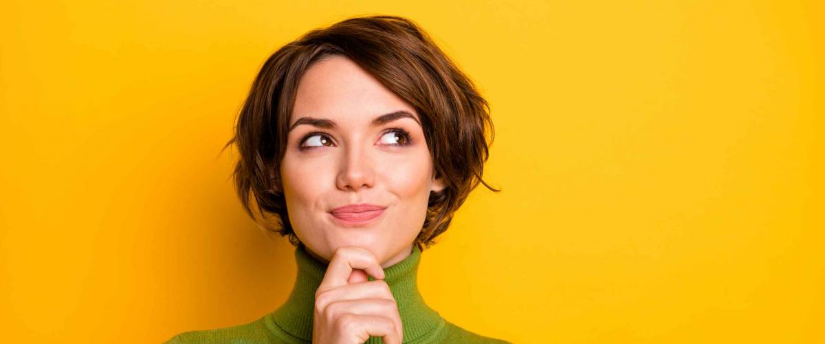 Closeup photo of lady in green turtleneck thinking