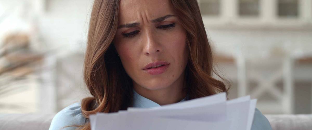 Closeup sad business woman reading documents at home office. Upset woman frustrating with papers in slow motion.