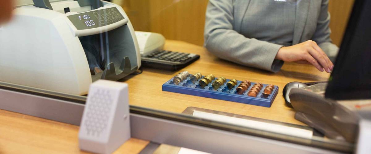 bank teller counts coins