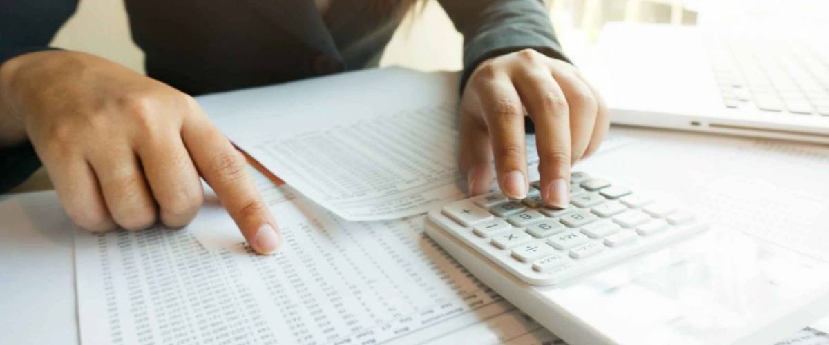 woman adding up numbers with calculator