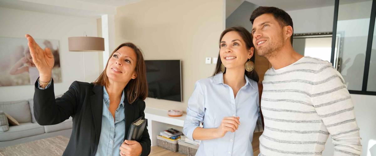 couple looks at house with real estate agent