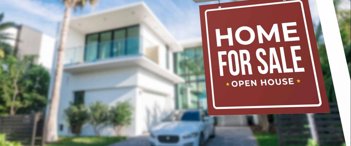 Home For Sale and Open House Real Estate Sign in front of a contemporary minimalist house in a tropical setting.