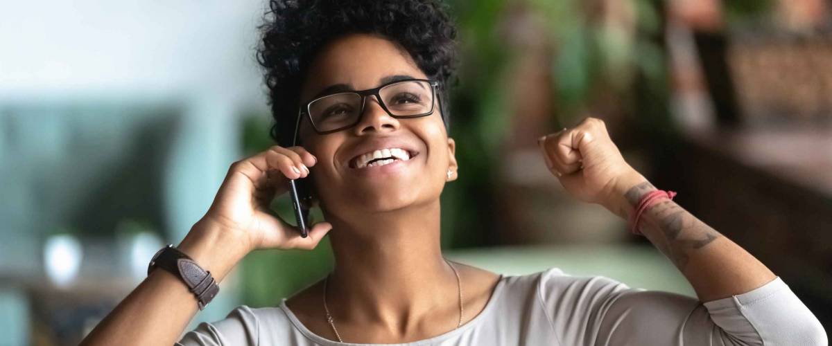 Happy black businesswoman laughing with joy, on the telephone
