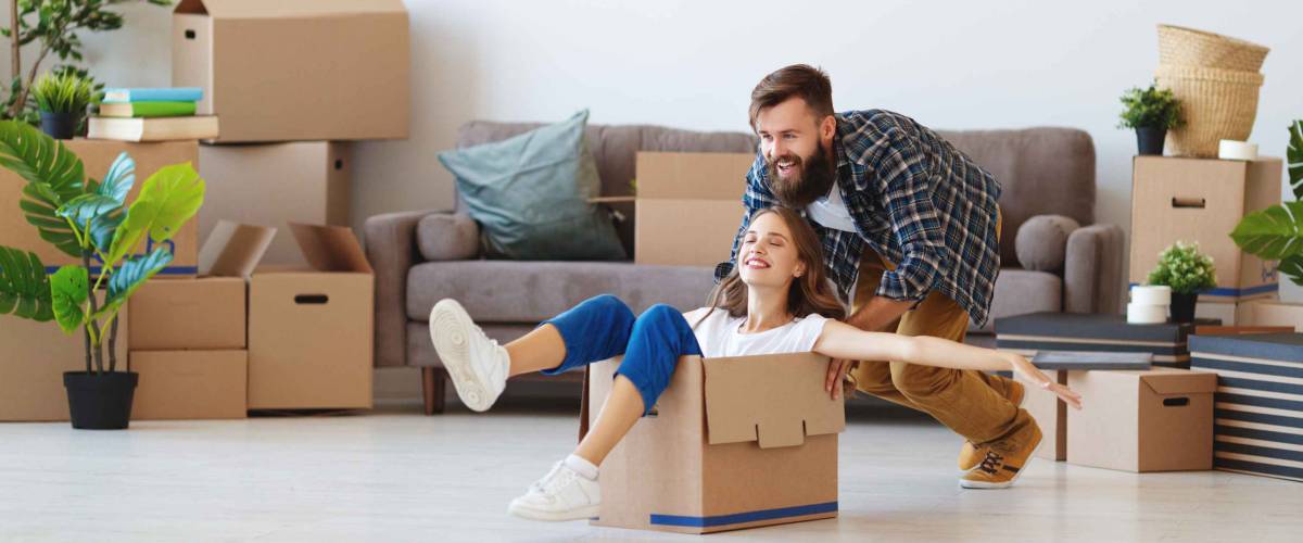 a happy young married couple moves to new apartment