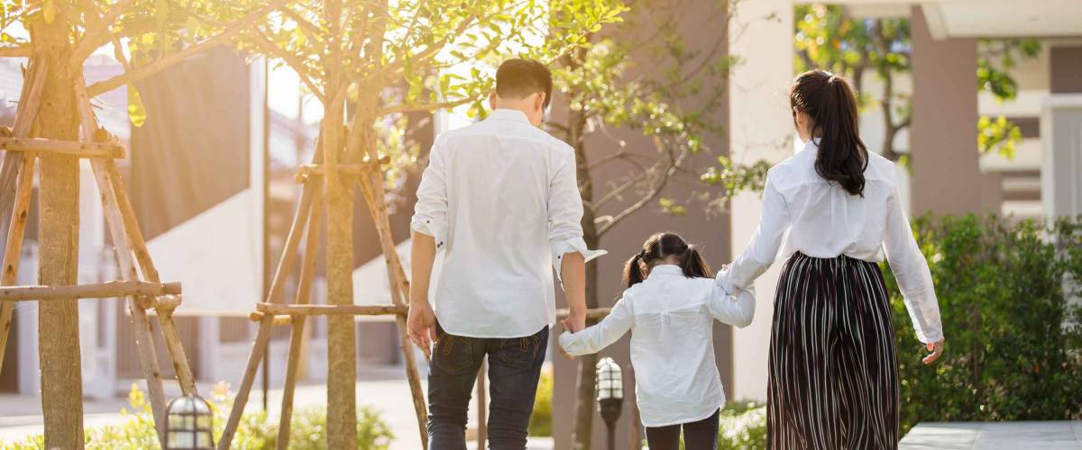 Asian family are going out of the house , Parents and children were walking hand in hand together a happy in garden.