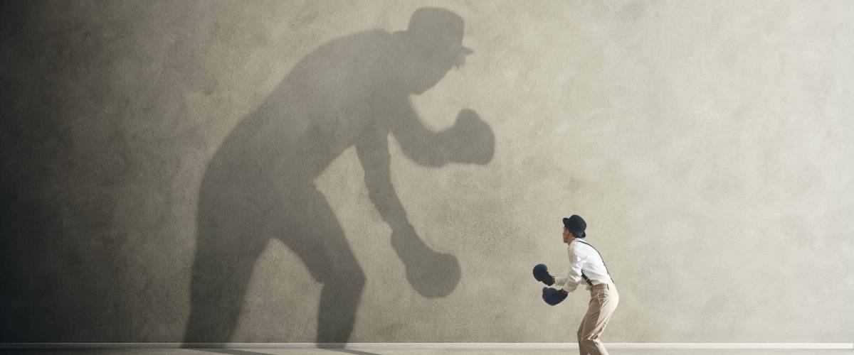 man fighting with his shadow, facing fears