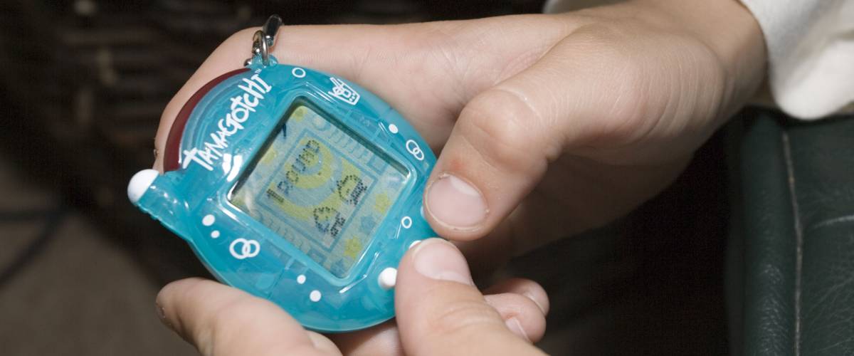 Hands holding a Tamagotchi toy