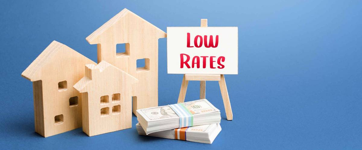 Figurines of houses and an easel with low rates.
