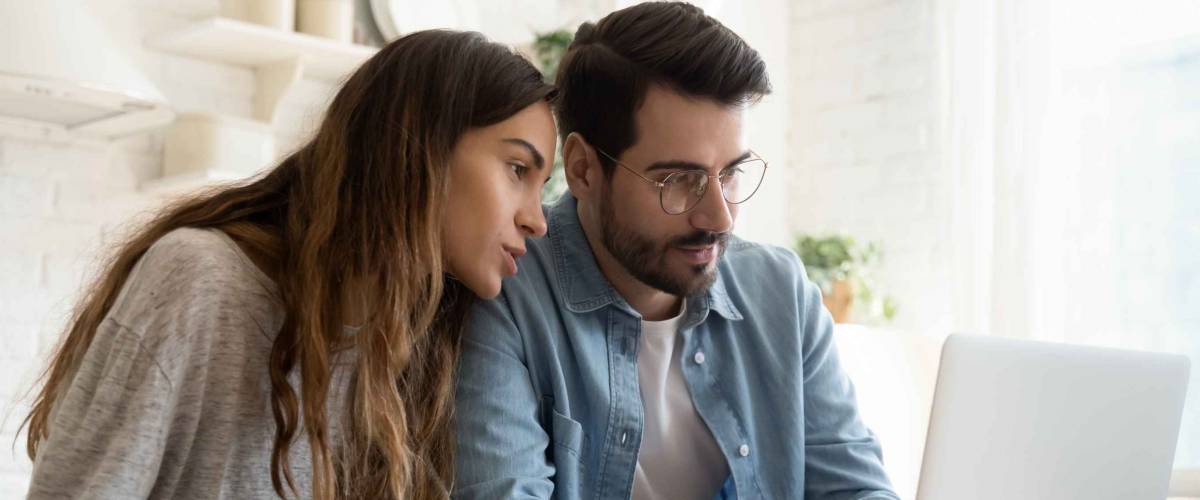 focused young couple looking at computer screen together