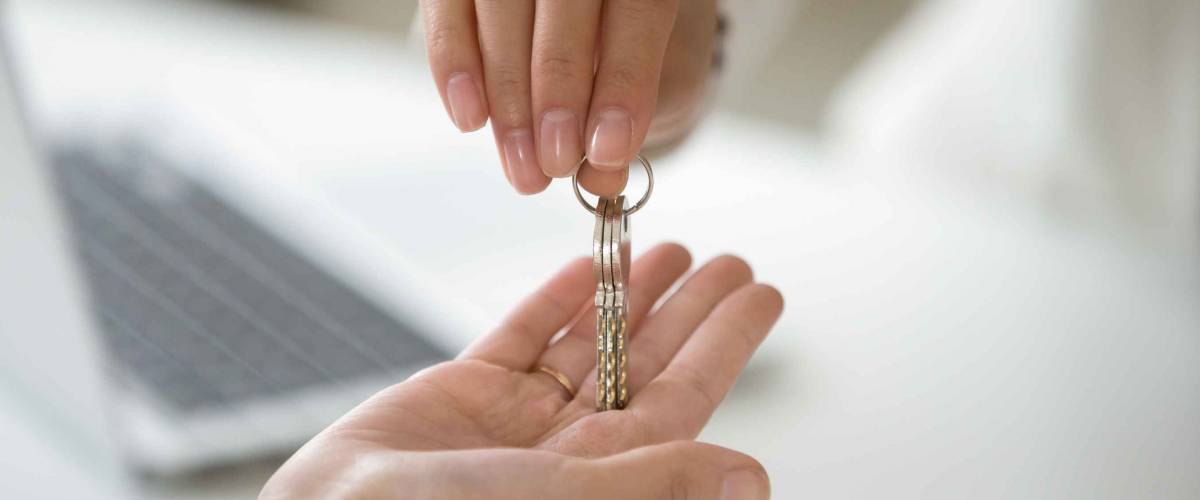 woman's hands drops set of keys into open palm