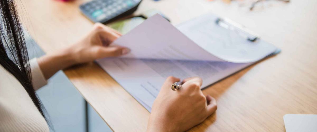 Woman signing paperwork at desk