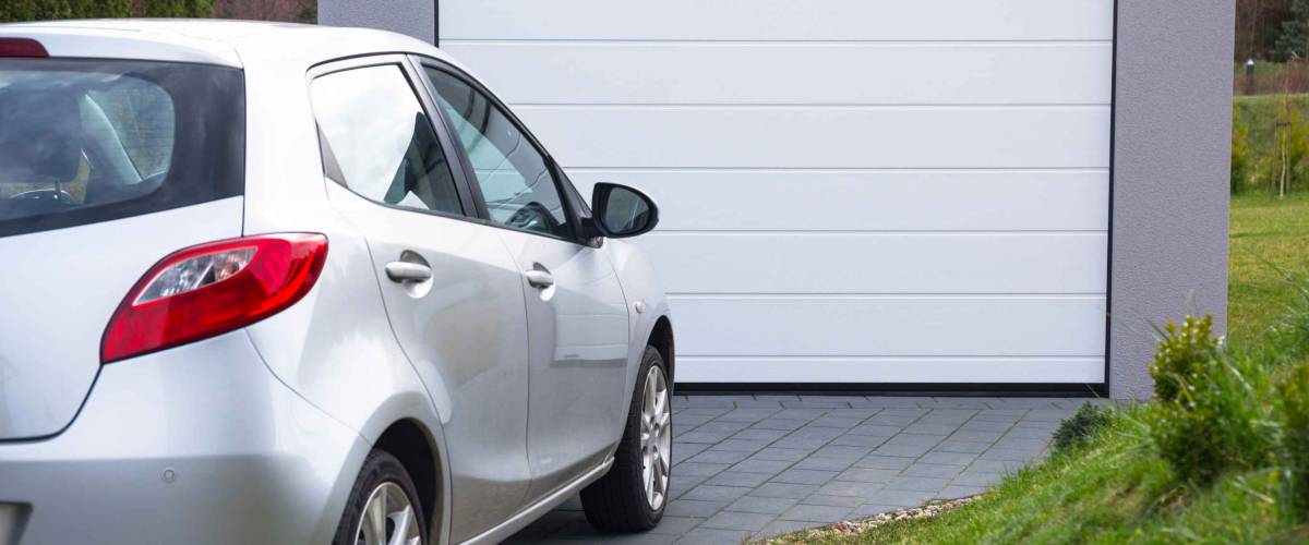 Free-standing garage in the garden with a car parked in front of the gate