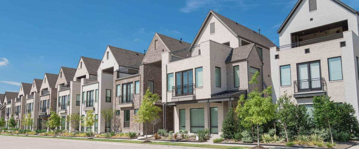 Row of brown townhouses with trees in front
