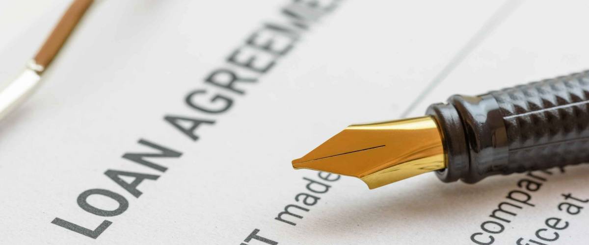 Business loan agreement or legal document concept : Fountain pen on a loan agreement paper form.