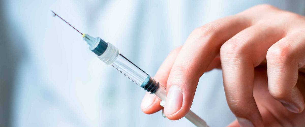 Syringe, medical injection in hand, palm or fingers. Medicine plastic vaccination equipment with needle. Nurse or doctor. Liquid drug or narcotic. Health care in hospital.