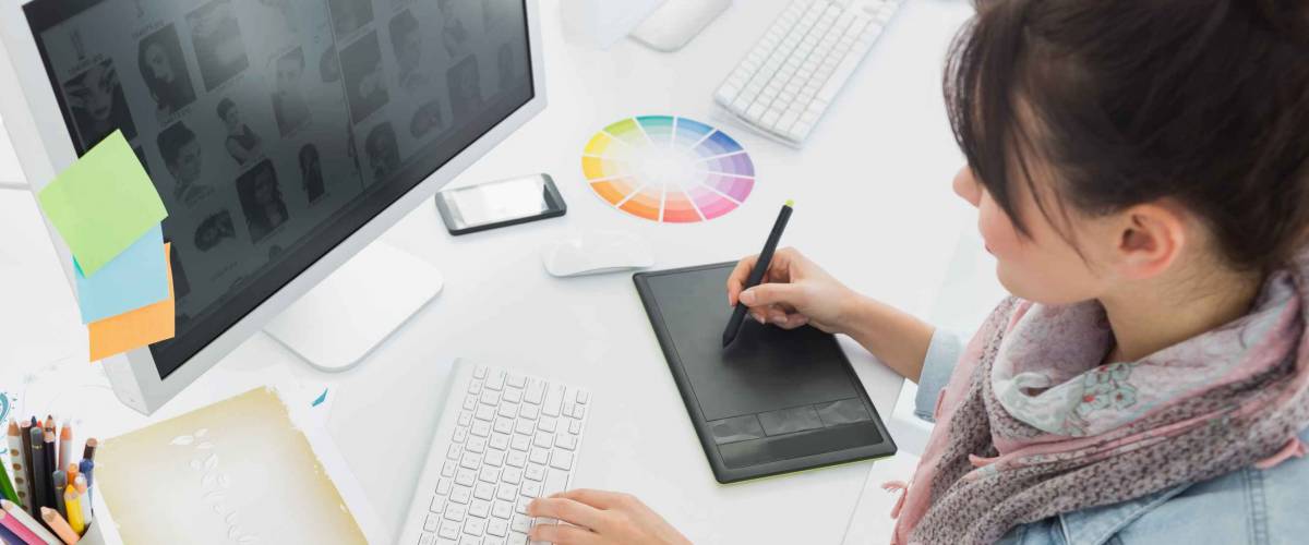 High angle view of an artist drawing something on graphic tablet at the office