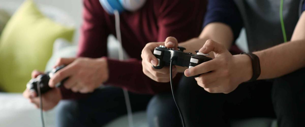 Teenagers playing video games at home