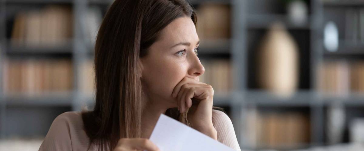 Stressed young woman holding document