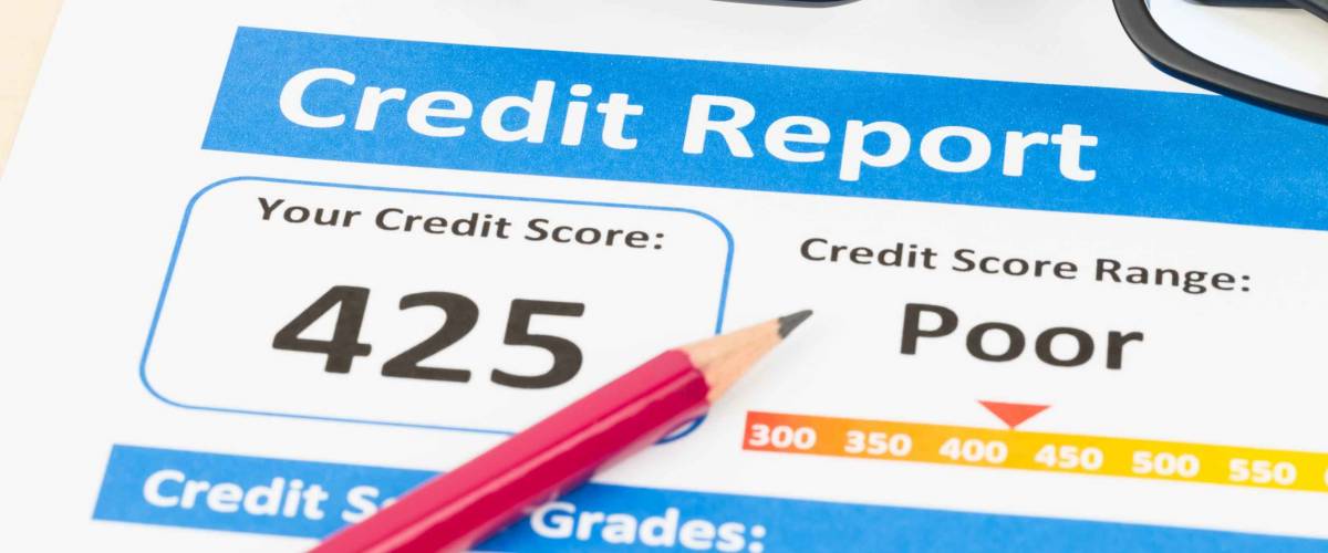 Poor credit score report with pen and calculator