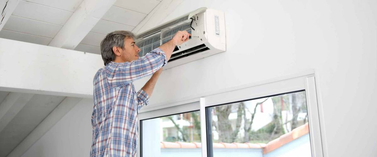Repairman fixing air conditioner unit