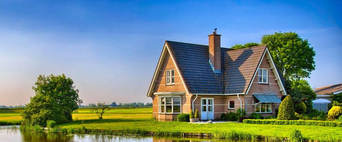 cute house in the countryside, beside a body of water and a field