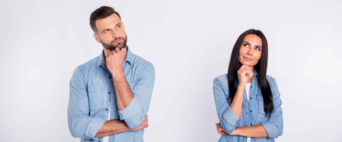 Man and woman both wearing blue shirts, looking quizzical