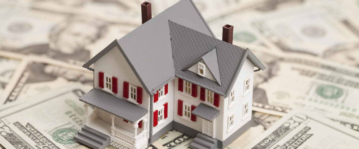 Single family house on pile of money. Concept of real estate.