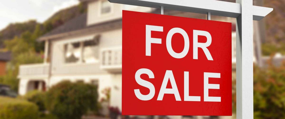 Real estate sign in front of new house for sale