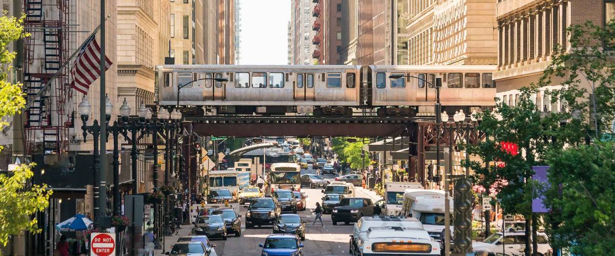 Traffic in downtown Chicago with people, train, car and bus