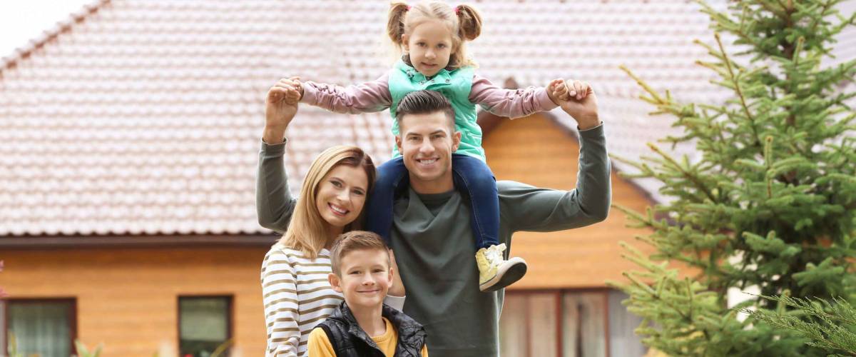 Happy family in courtyard near their house