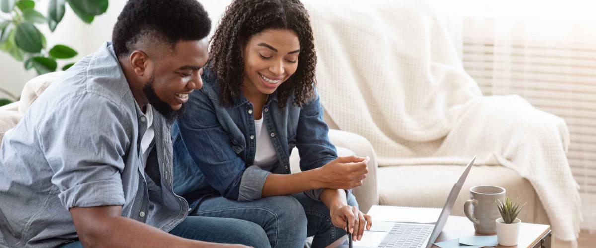 Household Budget. Smiling Black Couple Discussing Total Amount Of Their Spends At Home, Happy About Wise Planning